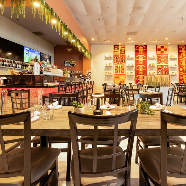 Interior of 305 Peruvian Modern Cuisine, featuring a bar, dining tables, and Peruvian-inspired wall decor.